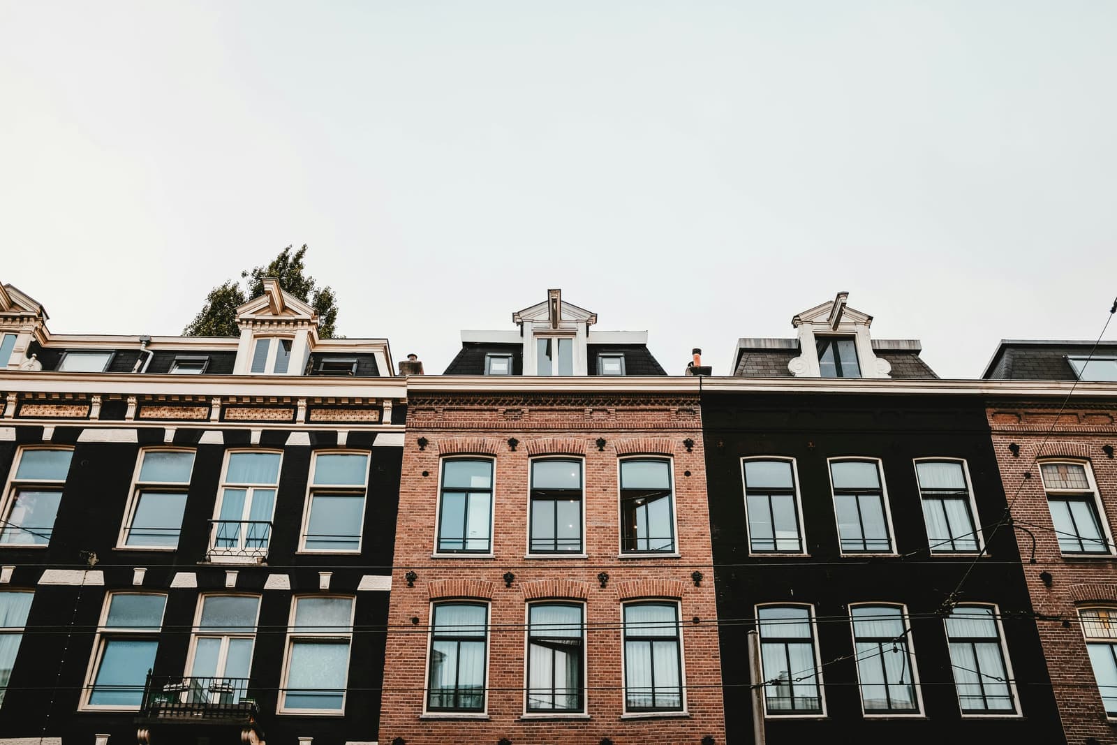 A row of brick apartment houses with large windows in Amsterdam